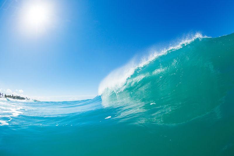 晴天阳光下海上翻滚的蓝色波浪