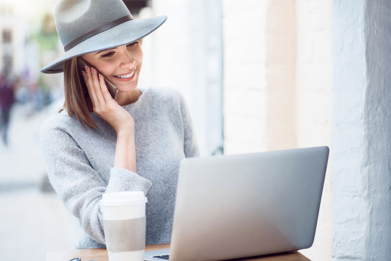 戴帽子的女人正在使用笔记本电脑