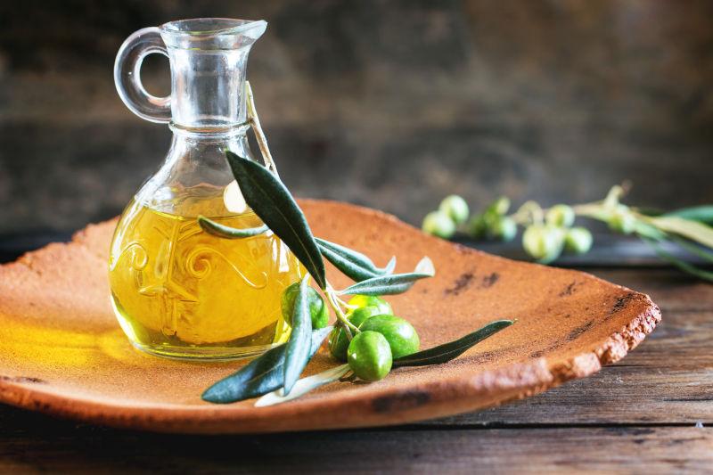 木桌盘子里的一瓶橄榄油