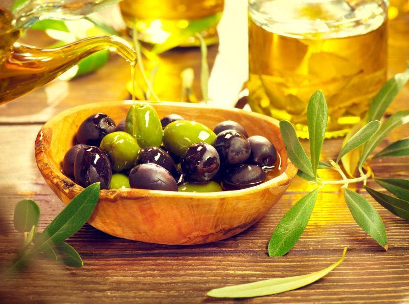木桌上的橄榄和新榨的橄榄油