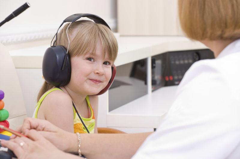 医生使用音乐测试戴着耳机的小女孩