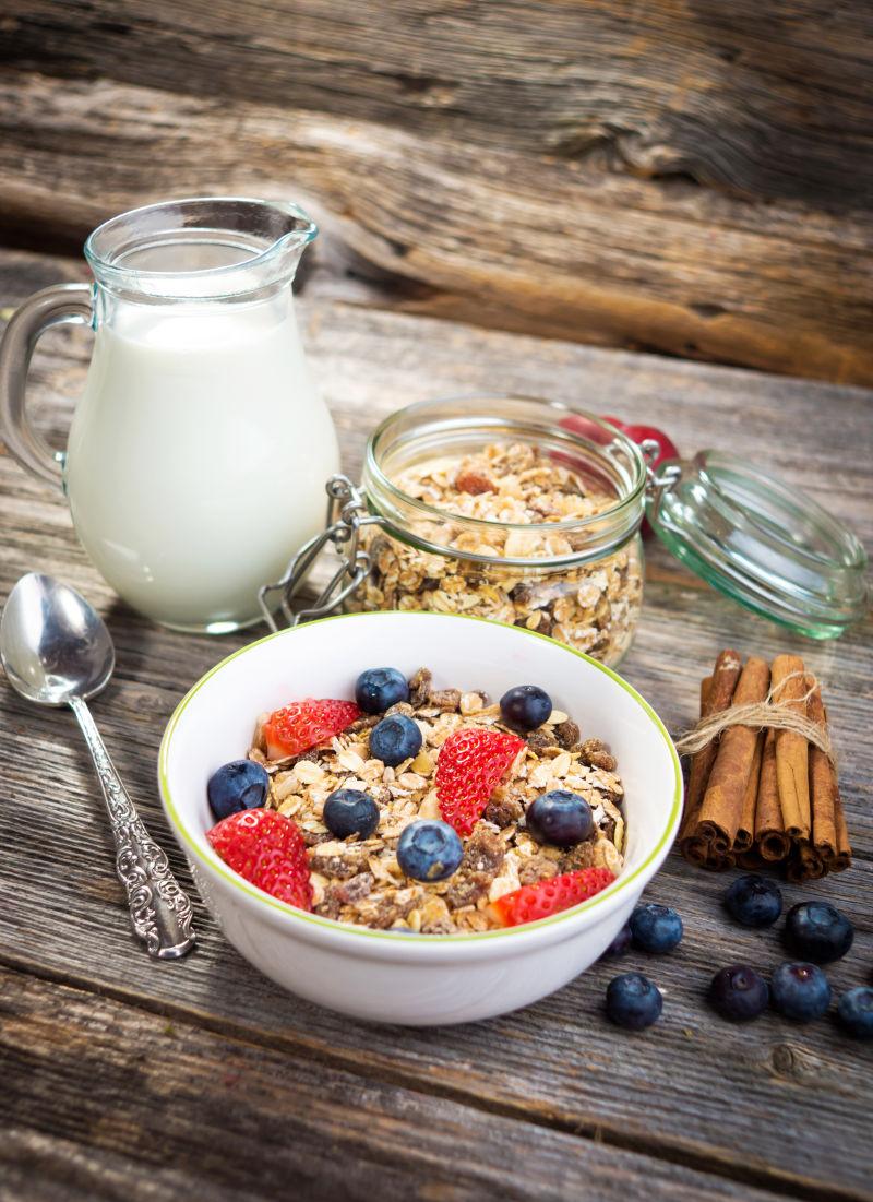 木质桌上的有燕麦片牛奶和浆果的健康早餐