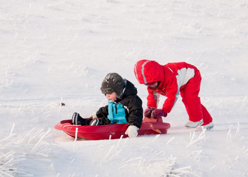 两个孩子在冬天滑雪橇