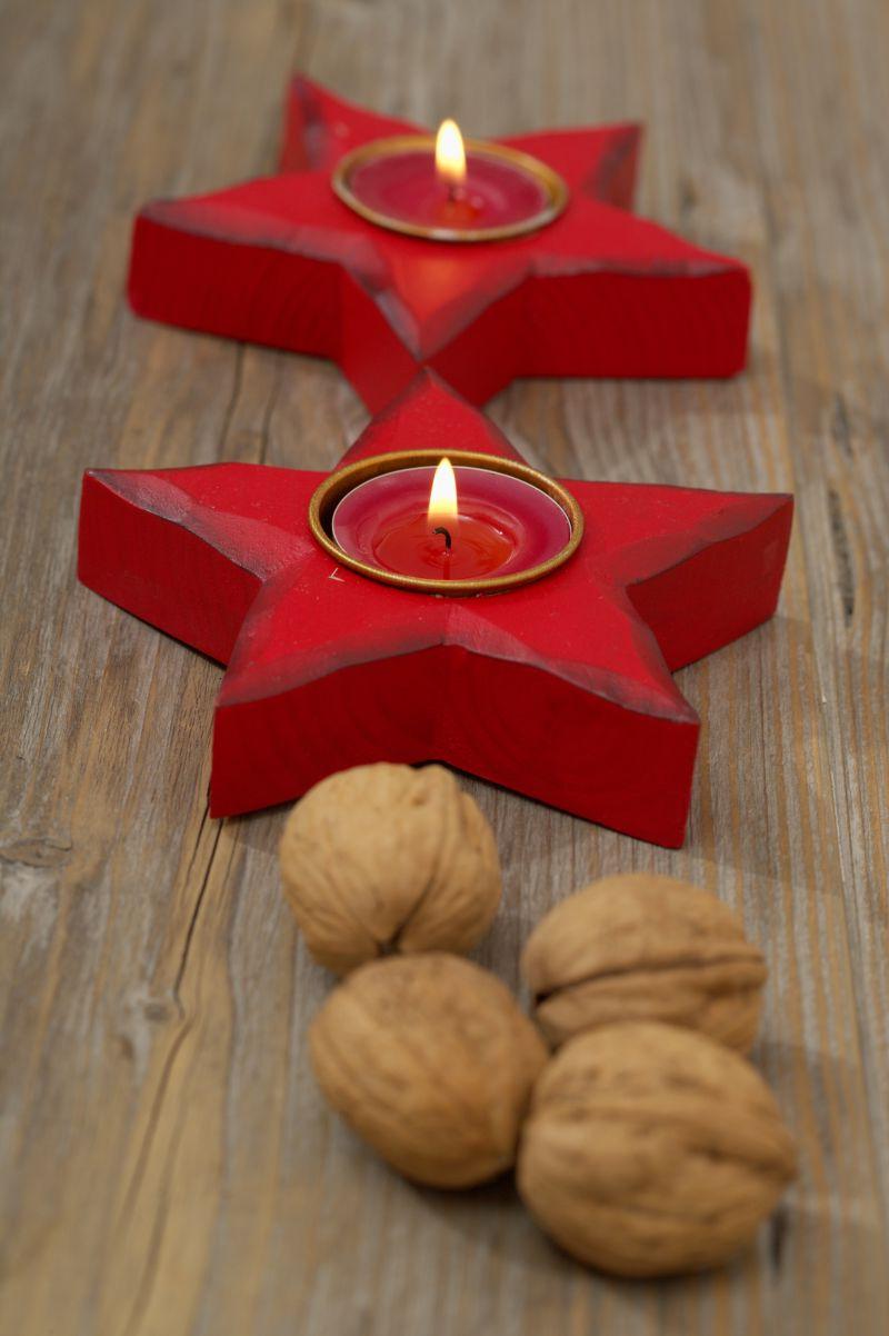 红色五角星内点燃的蜡烛和旁边的四个核桃