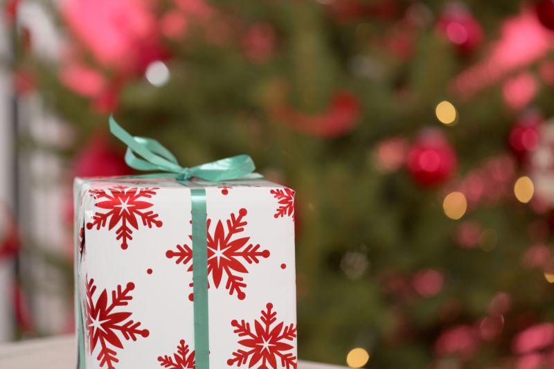 圣诞树边的桌子上有个雪花装饰的礼物盒
