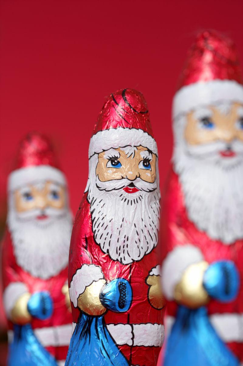 红色背景下的三个可爱的圣诞老人玩偶