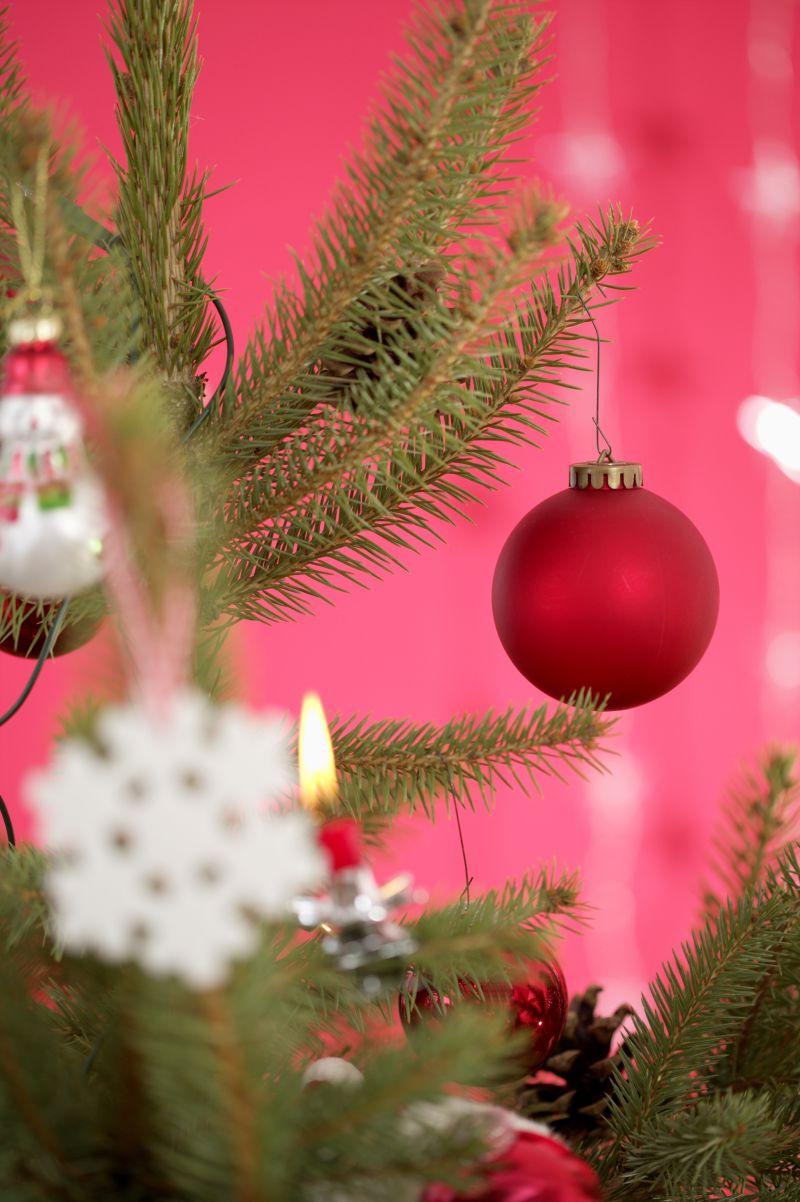 红色背景前的圣诞树上挂满了装饰品