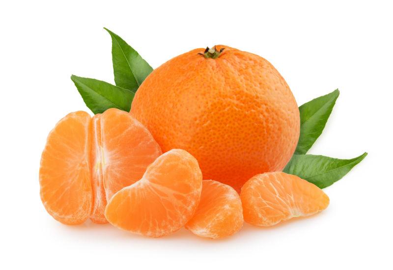 新鲜带叶的完整和切片的橘子在白色背景下