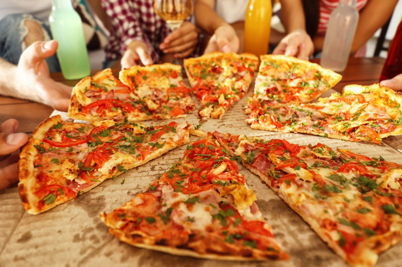 一群朋友围在一起吃披萨