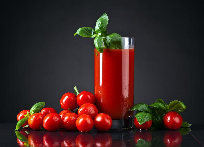 黑色背景下的番茄汁和小番茄