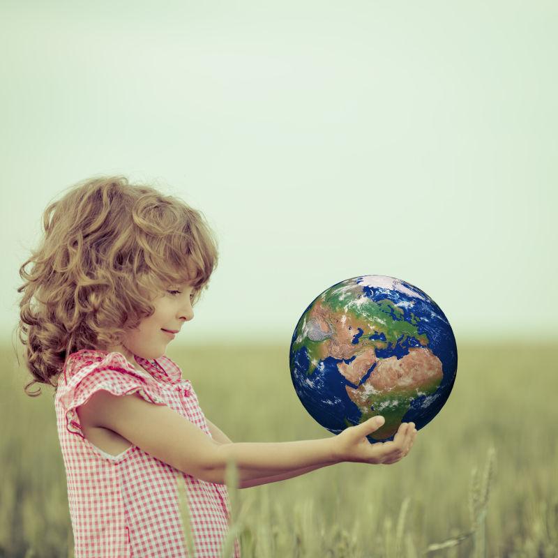 户外的小女孩手中托着地球创意