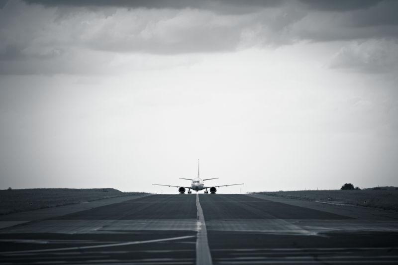 阴天有云的背景下跑道上降落-起飞的飞机