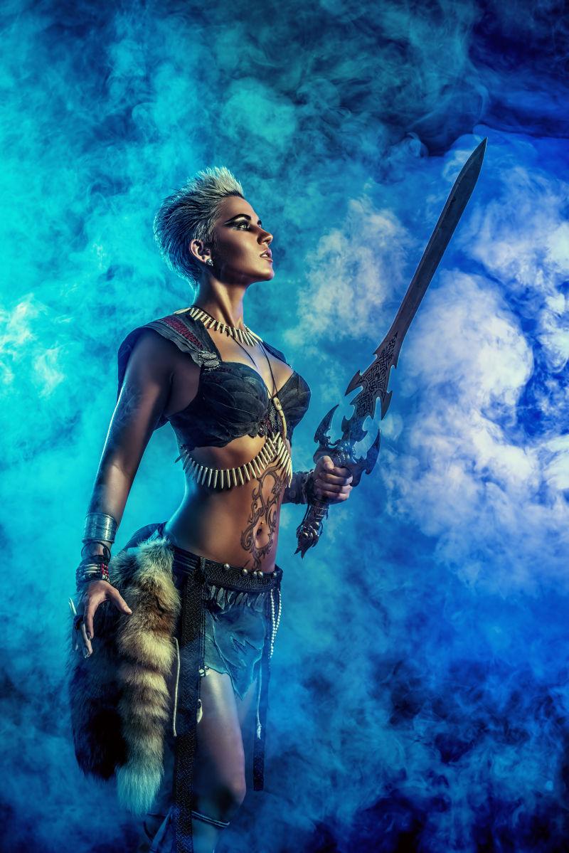在蓝色烟雾中拿着宝剑抬着头战斗的女战士