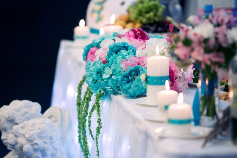 蓝色花朵和蜡烛装饰的婚礼餐桌