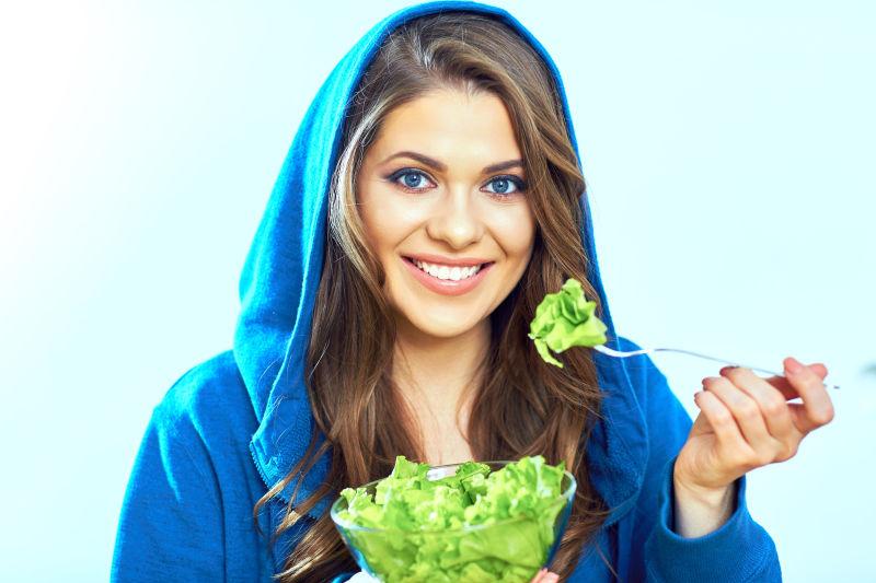微笑的美女吃蔬菜