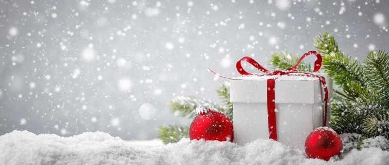 雪上的白色礼品盒和圣诞球