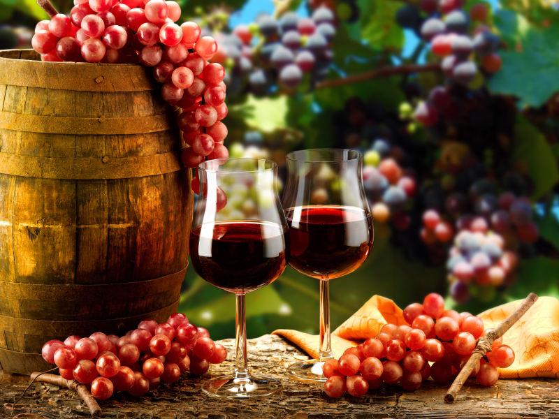 木桶旁边的葡萄酒与新鲜葡萄