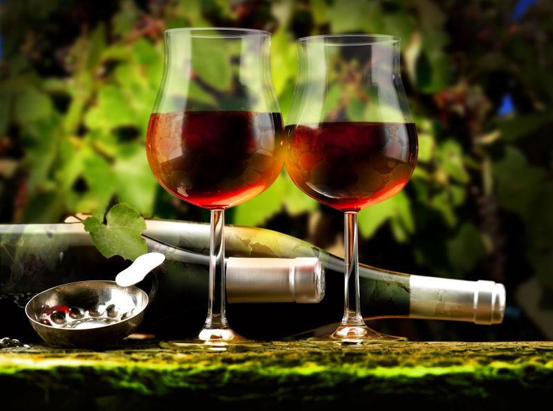 两瓶葡萄酒旁边酒杯中的葡萄酒