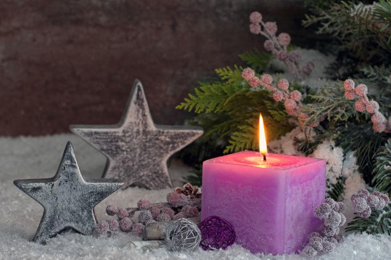 圣诞节装饰品与紫色燃烧的蜡烛