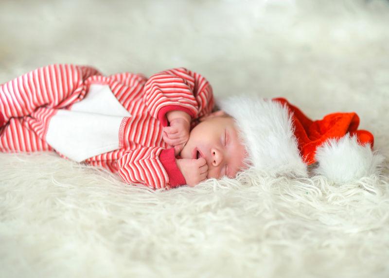 熟睡的新生的婴儿在白色地毯上