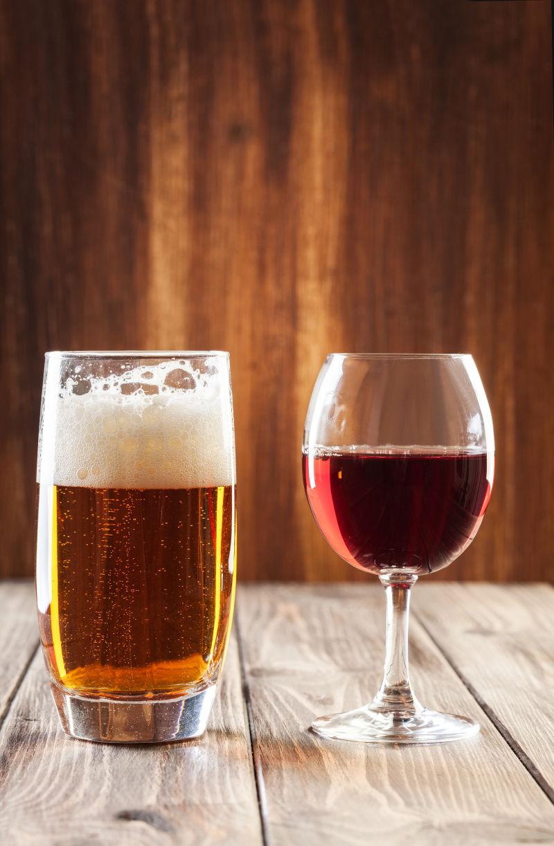 木板上的一杯啤酒和一杯红酒