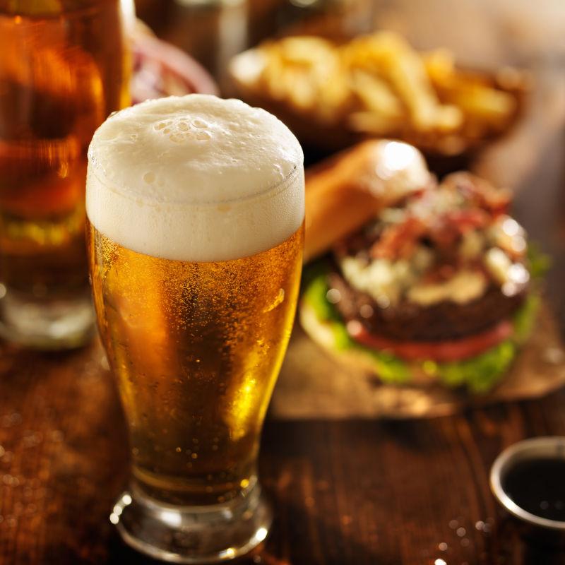 餐桌上的汉堡包和一杯满满的啤酒