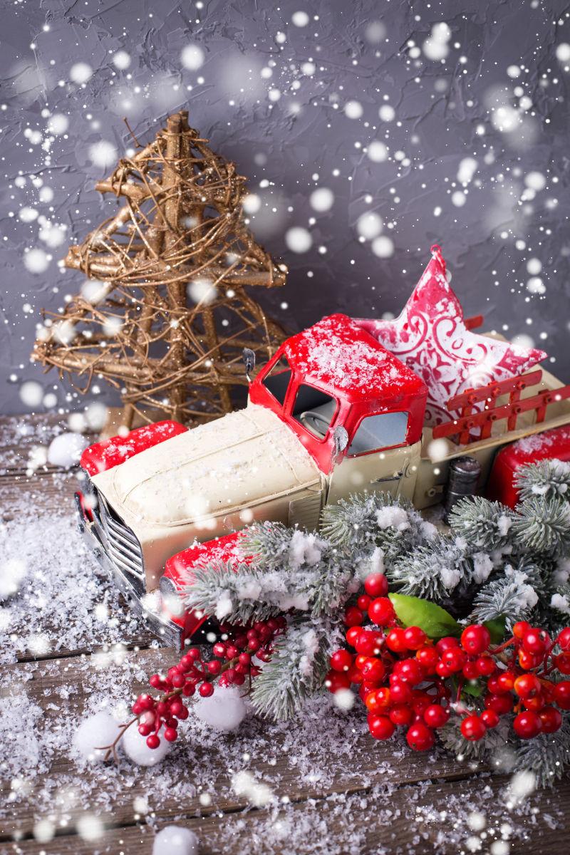 雪花下的卡车饰品和圣诞树饰品还有一株野生浆果