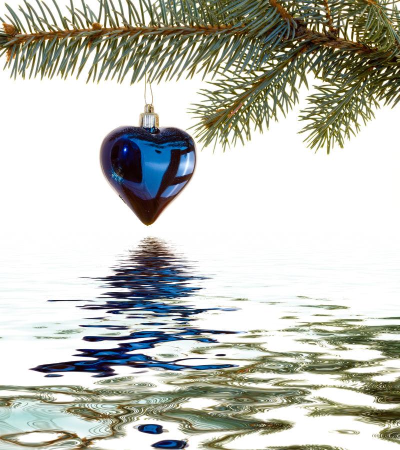 挂在圣诞枝上的蓝色爱心铃铛饰品