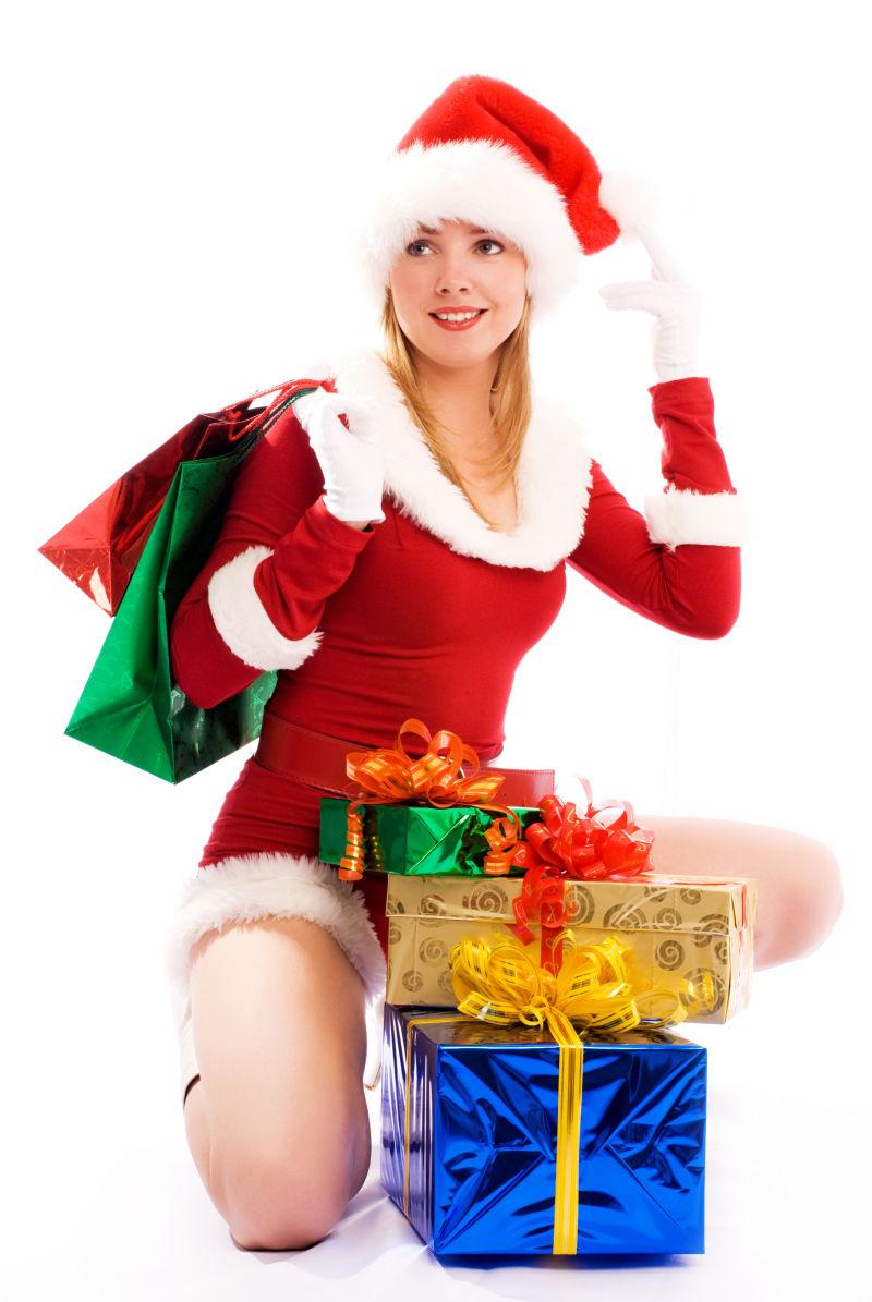 白色背景上穿着圣诞老人装束分发圣诞节节日礼物盒的美女