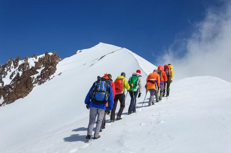 一群登山者正在努力攀登雪山