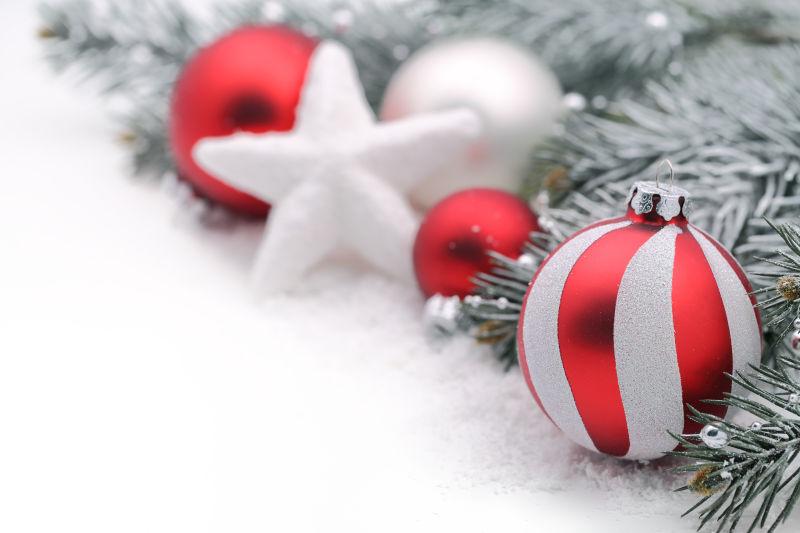 白色背景中的冷杉树枝玩具星星和红色圣诞球