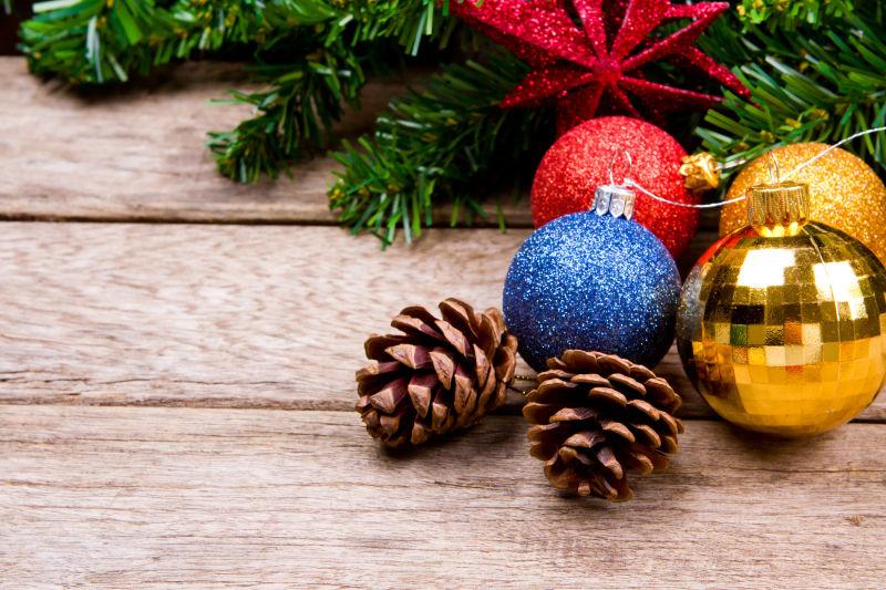 圣诞树上彩蛋装饰和木桌上的松子