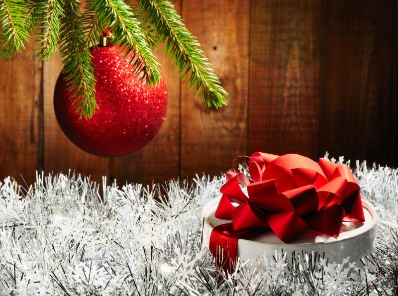 银色装饰品上的圣诞树枝和白色礼物盒
