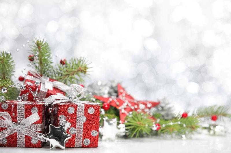 白色背景下的红色圣诞节礼物盒和松树枝