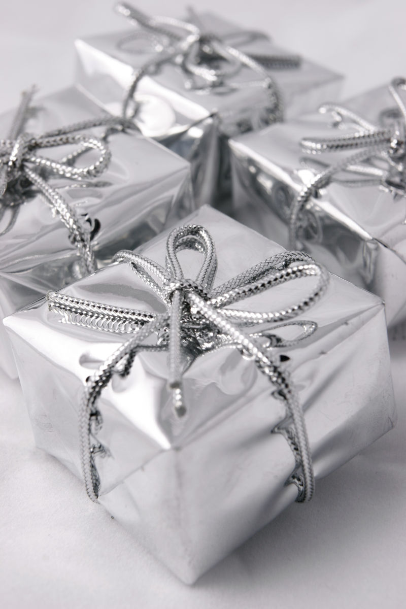 白色桌上的银色圣诞节礼物盒子