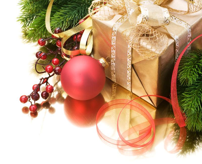 白色背景上的金色的圣诞节礼物盒和装饰品