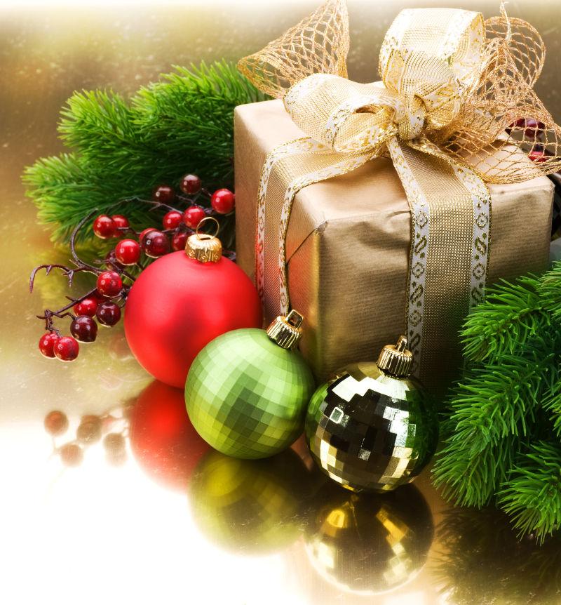 白色桌上圣诞树枝旁的金色圣诞节礼盒和装饰品
