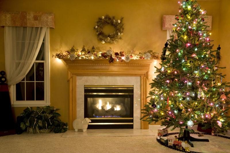 在温馨的室内闪着彩灯的圣诞树和温暖的壁炉