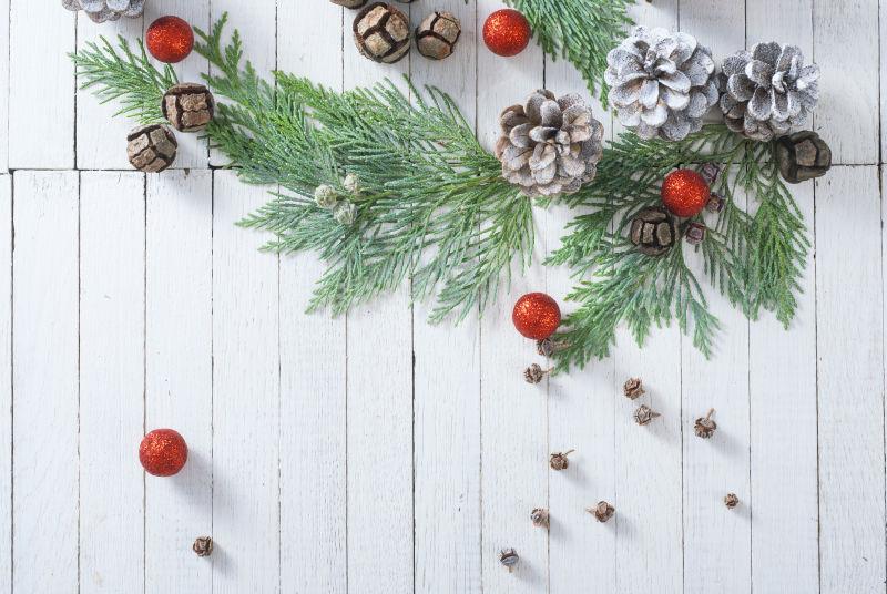 白色木板上装饰着树枝和各种美丽的圣诞饰品