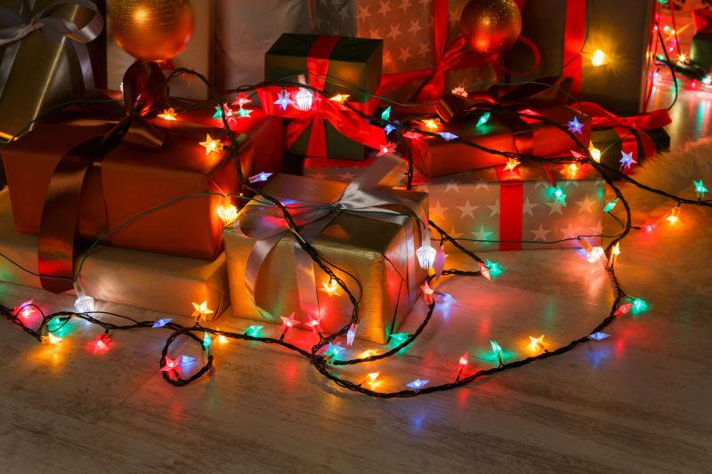 白色地板上的圣诞节小彩灯和礼物盒子