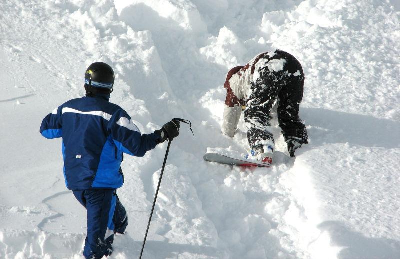 阳光下掉进雪堆里的滑雪者