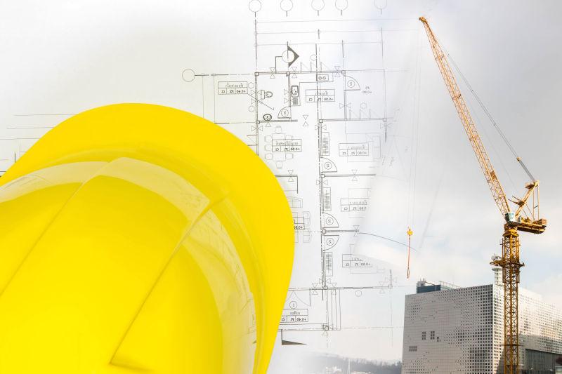 建筑施工现场图纸与黄色的安全帽