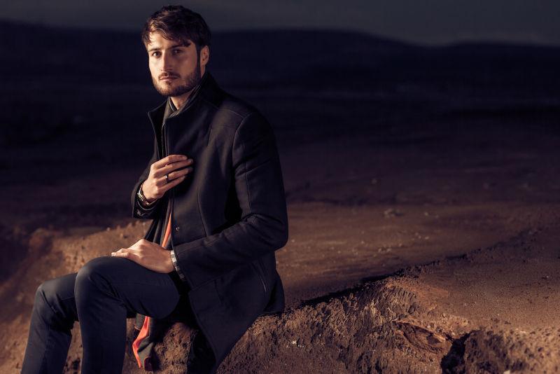 沙漠中坐着的英俊男性模特