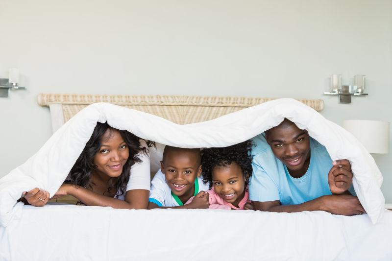 幸福的家庭躺在家里的床上