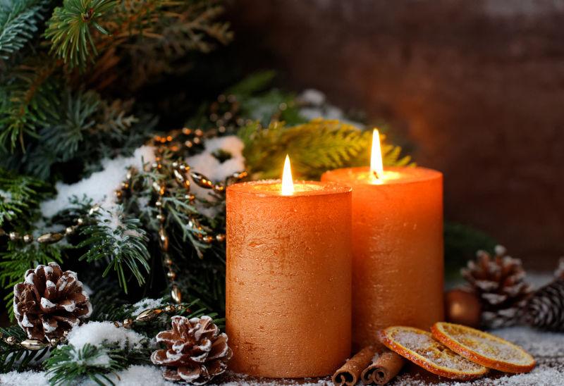燃烧的橘色圣诞蜡烛与装饰