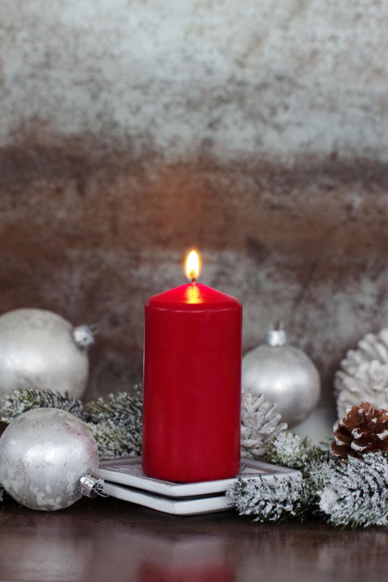 燃烧的圣诞红色蜡烛与装饰品