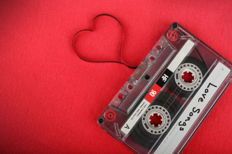 红色的背景下老式录音磁带松散的磁带形成爱心