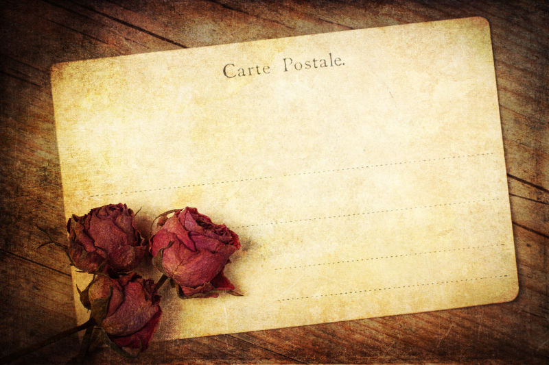 木制背景下的旧玫瑰明信片