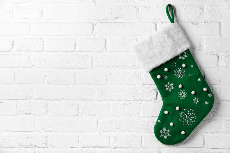 白色墙面上挂着绿色圣诞袜子