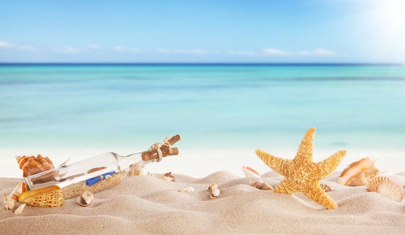 夏日沙滩上的海星和漂流瓶